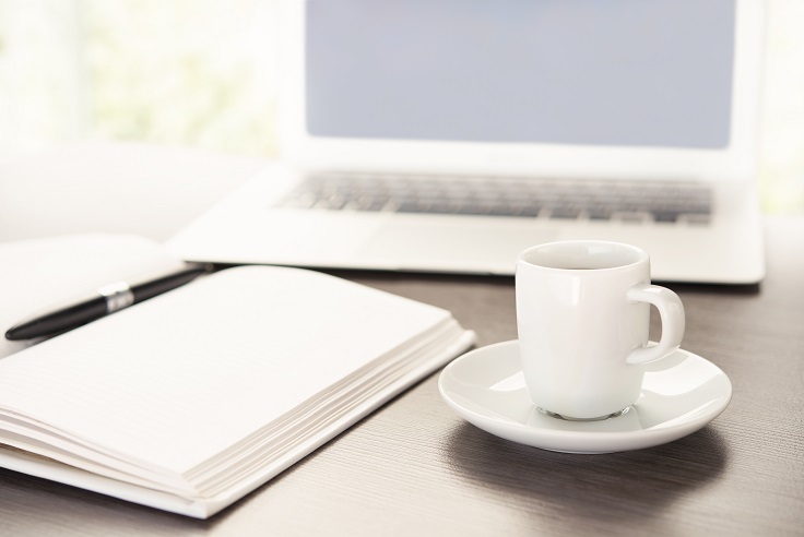 work office desk with a cup of coffee computer laptop, notebook, pen